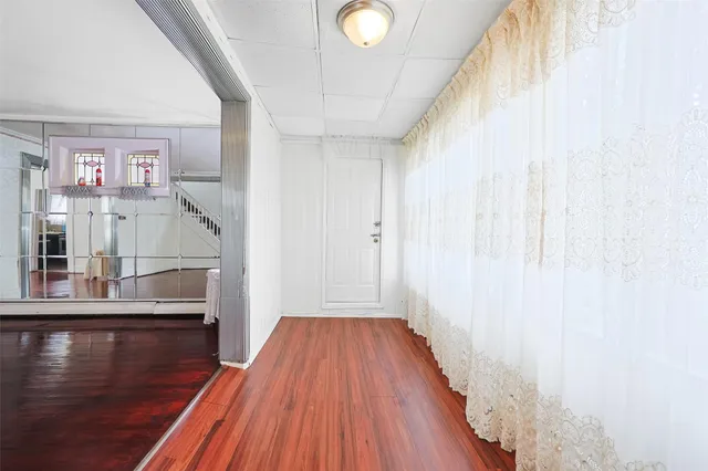 a view of a hallway with wooden floor and dining room