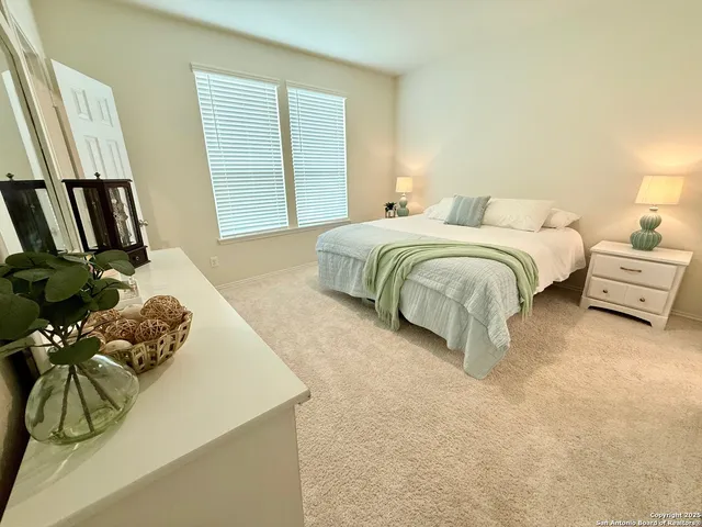 a bedroom with a bed and a flat tv screen on the dresser