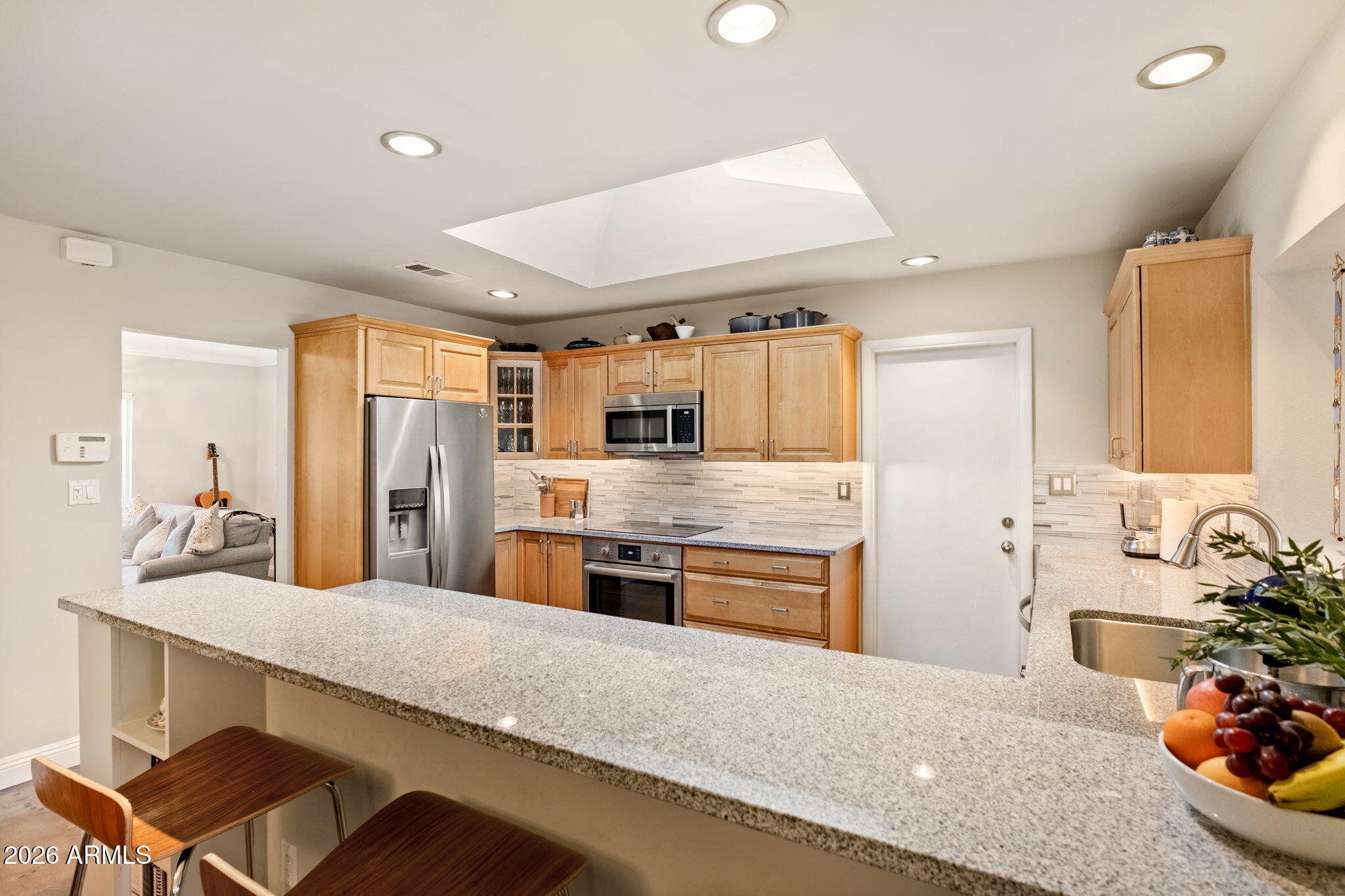 4901 North 82nd Street Scottsdale, AZ 85251 - Photo 18 of 48 a large kitchen with stainless steel appliances kitchen island granite countertop a sink and cabinets