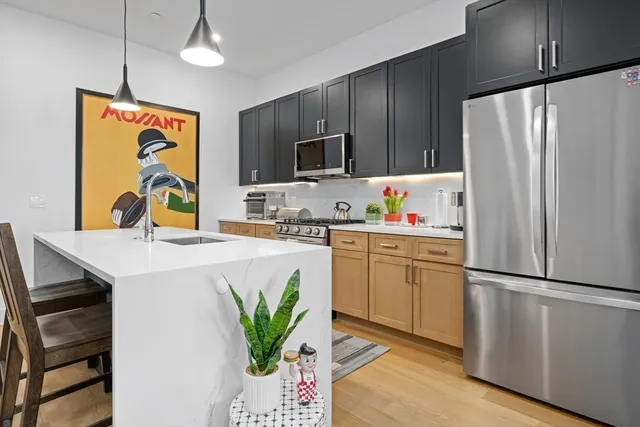 a kitchen with stainless steel appliances a refrigerator sink and microwave