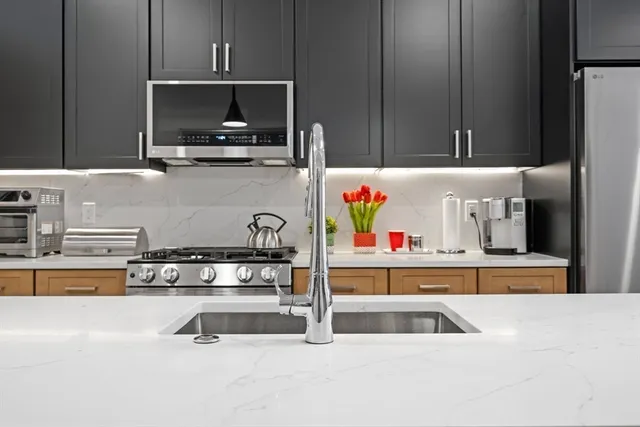 a kitchen with kitchen island a sink and a stove with wooden floor