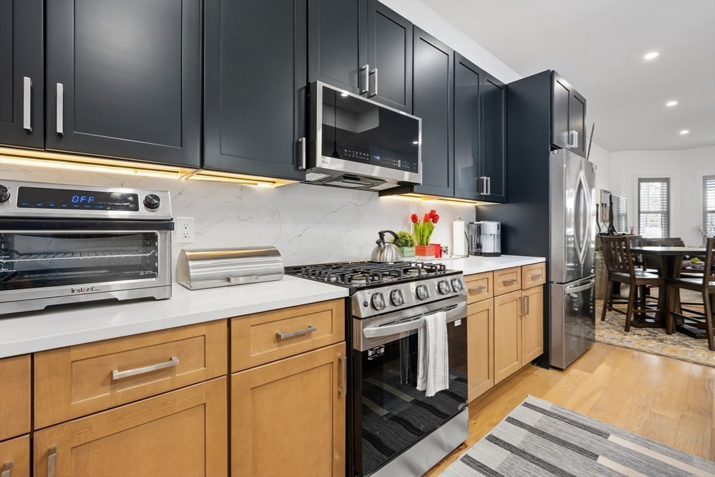 231 Everett Street, Unit 1 Boston, MA 02128 - Photo 15 of 39 a kitchen with stainless steel appliances a stove microwave and refrigerator