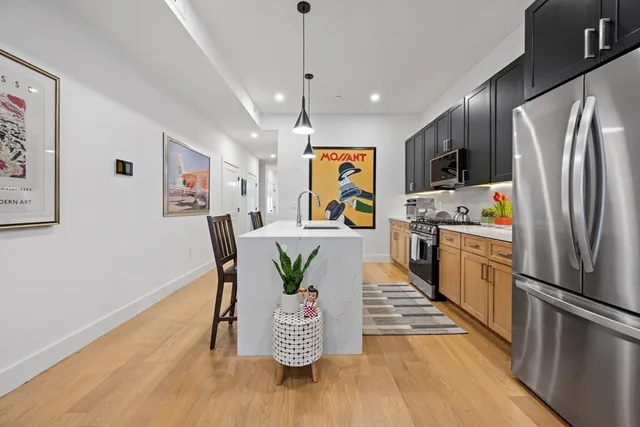 a kitchen with stainless steel appliances granite countertop a refrigerator a stove a microwave oven a sink with island and chairs