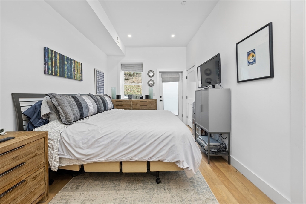 231 Everett Street, Unit 1 Boston, MA 02128 - Photo 22 of 39 a bedroom with a bed and wooden floor