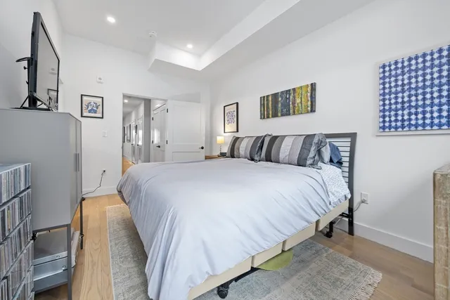 a bedroom with a bed and painting on the wall