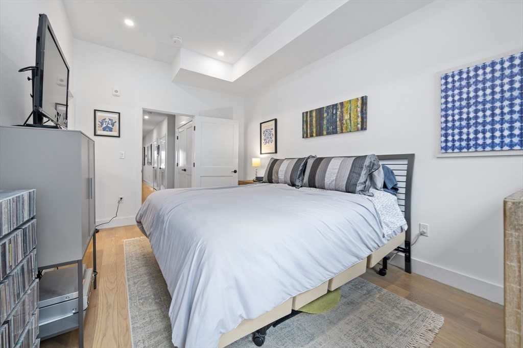 231 Everett Street, Unit 1 Boston, MA 02128 - Photo 25 of 39 a bedroom with a bed and painting on the wall
