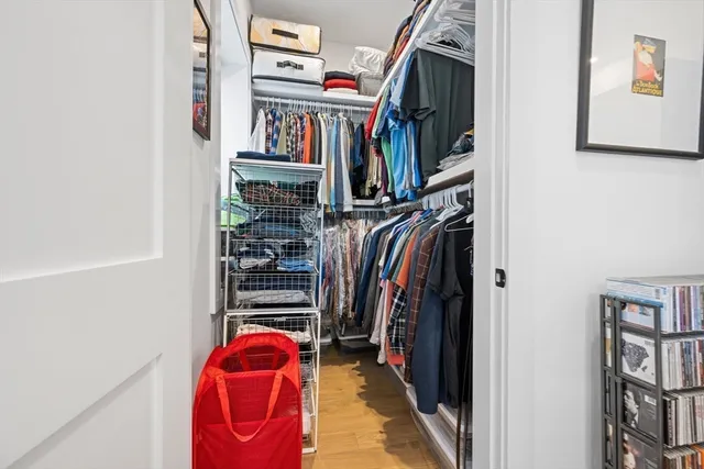 a view of walk in closet with clothes and shoes