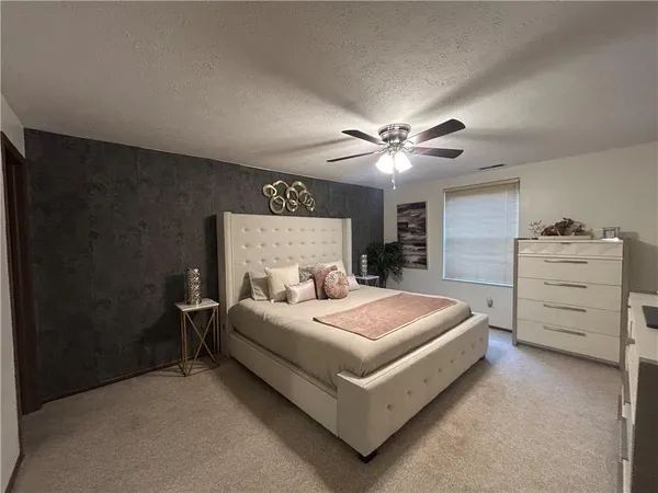 a bedroom with a large bed and a chandelier