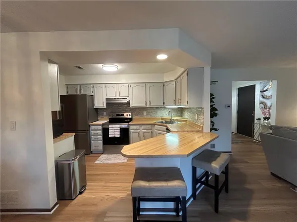 a kitchen with a table chairs refrigerator and cabinets