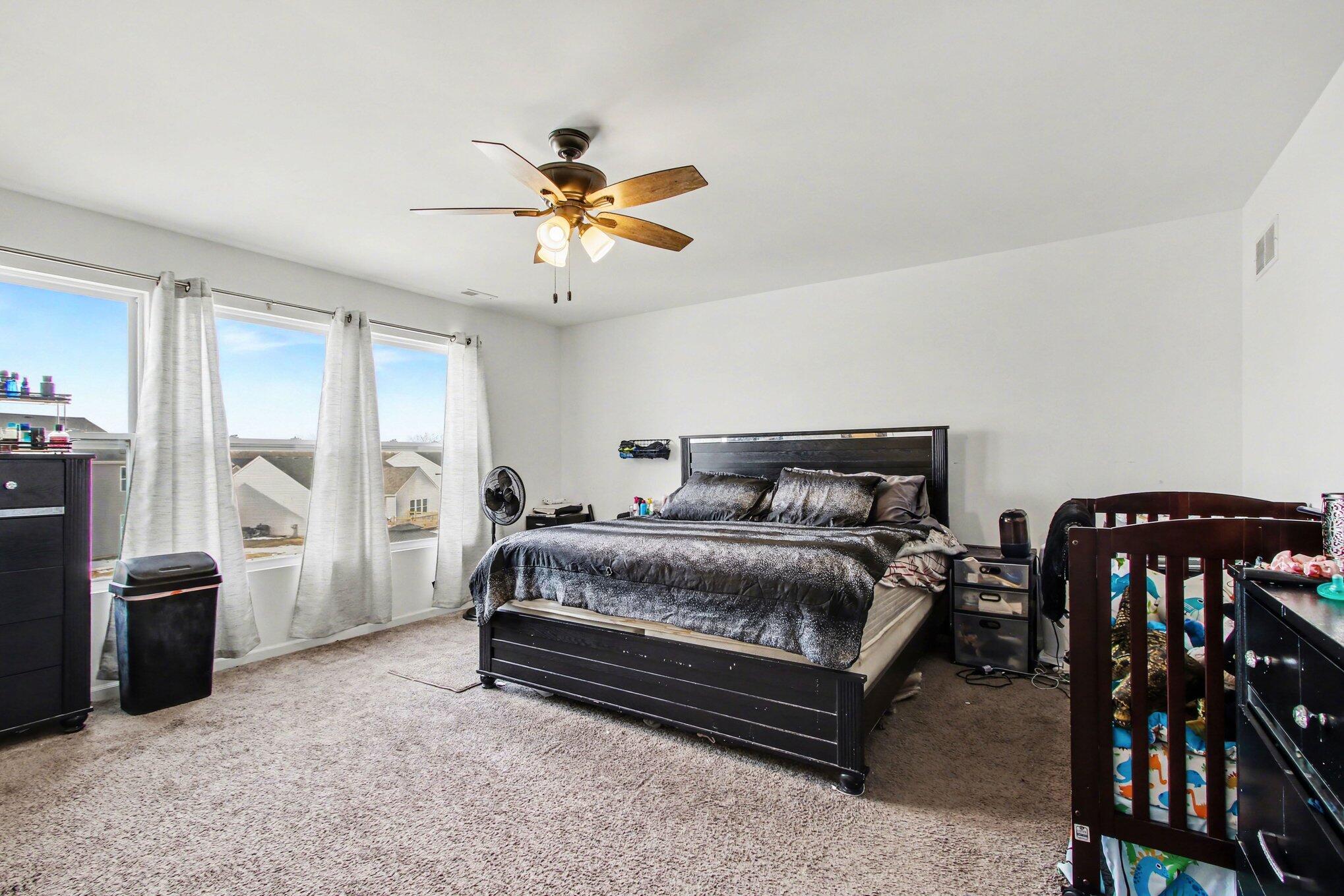 7480 Williams Street Merrillville, IN 46410 - Photo 28 of 49 a spacious bedroom with a bed and a chandelier