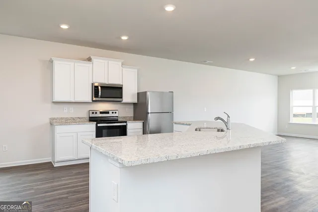 a kitchen with stainless steel appliances granite countertop a sink refrigerator and microwave