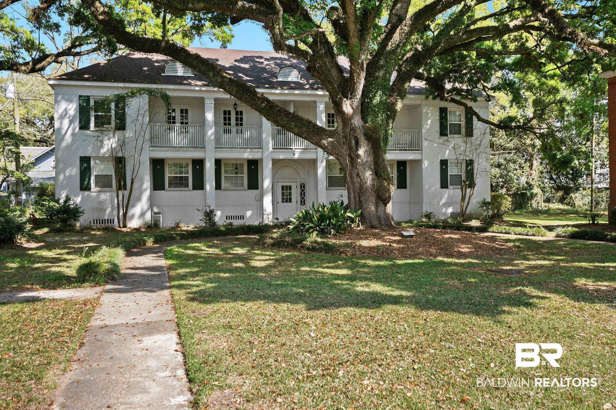 214 Upham Street, Unit 8D Mobile, AL 36607 - Photo 1 of 36 Neoclassical / greek revival house with a balcony, a front lawn, and stucco siding