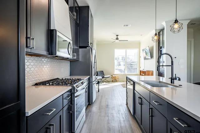 a kitchen with a sink stove top oven and cabinets
