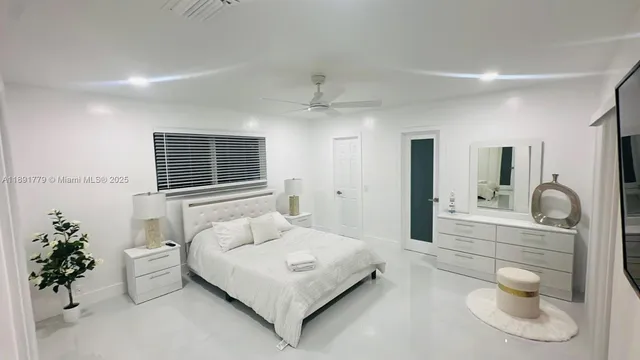 a spacious bedroom with a bed and a chandelier