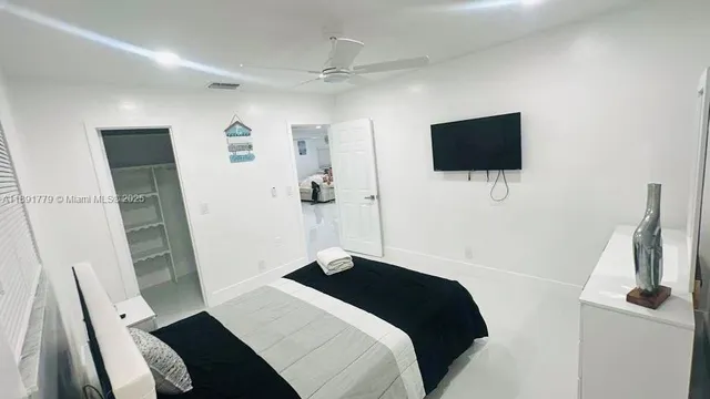 a bedroom with a bed and a flat screen tv