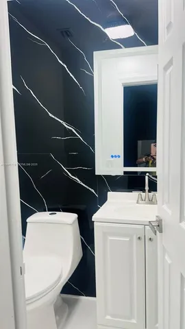 a bathroom with a toilet a sink and a mirror