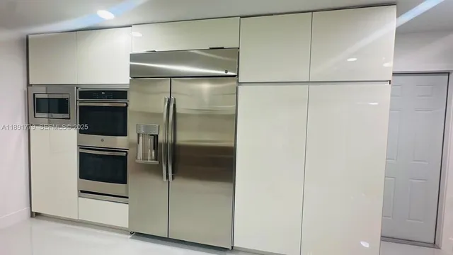 a metallic refrigerator freezer sitting in a kitchen