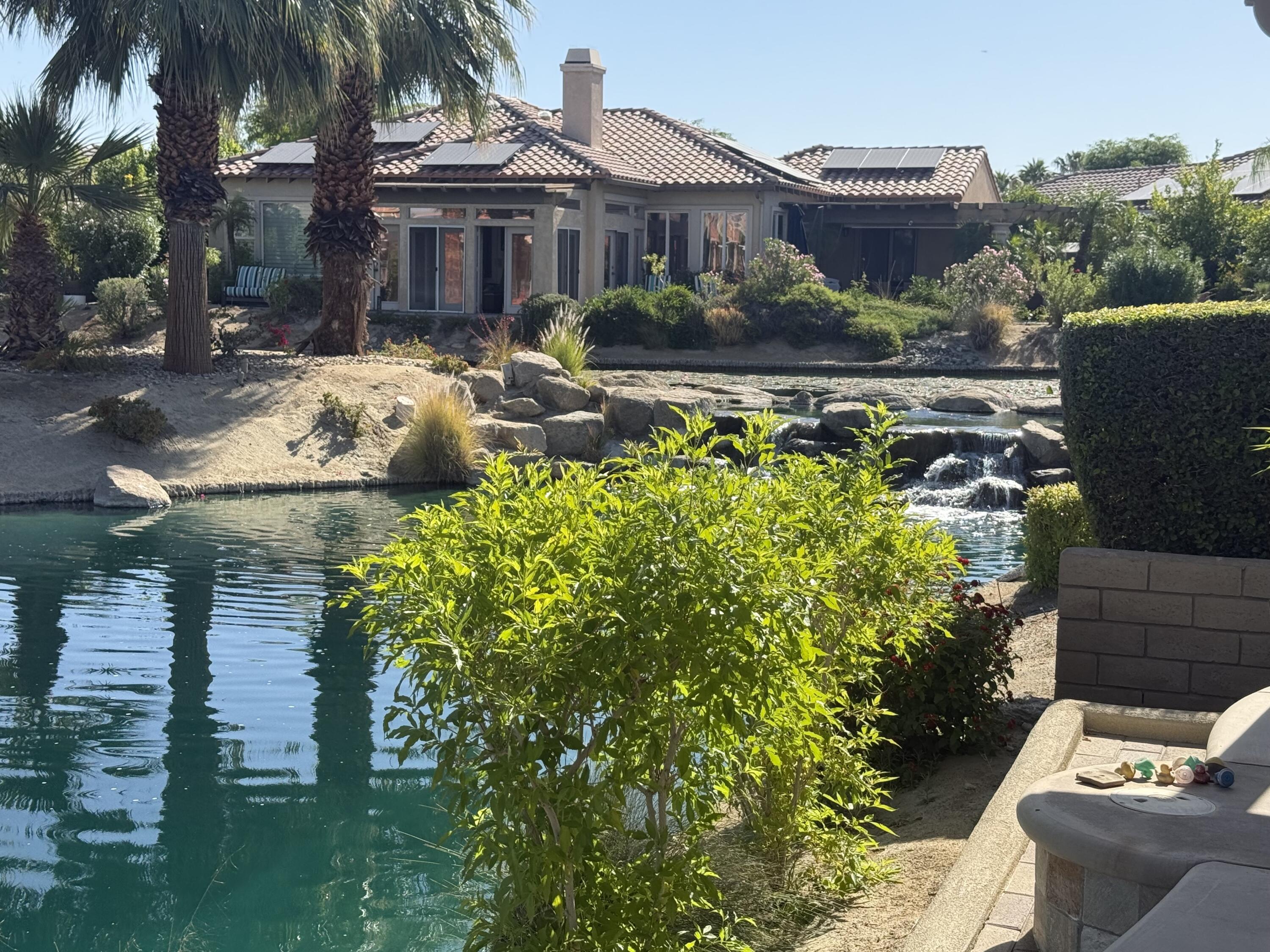 59 Shoreline Drive Rancho Mirage, CA 92270 - Photo 49 of 56 a front view of a house with a garden