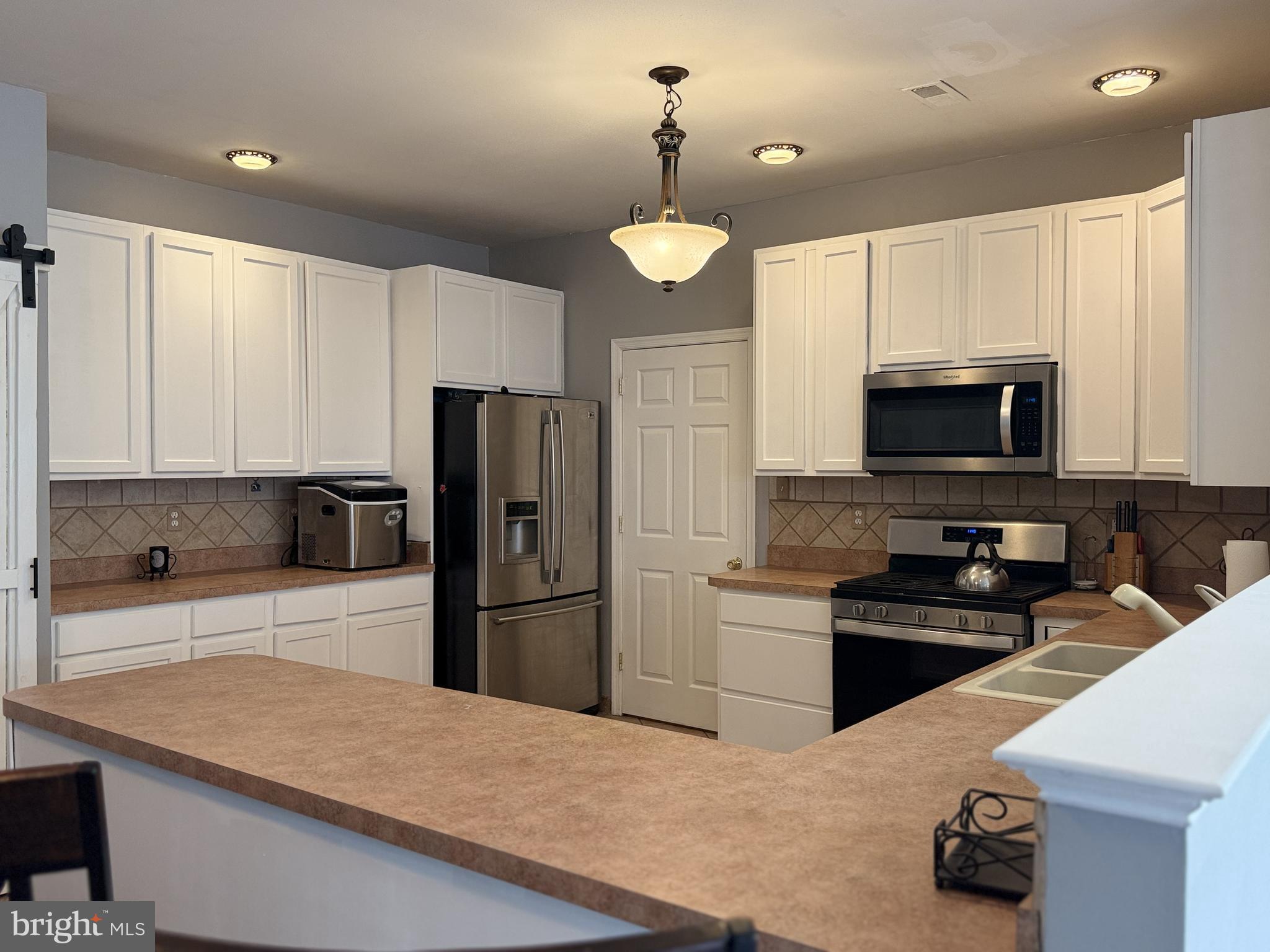 135 Juniper Lane Swedesboro, NJ 08085 - Photo 5 of 40 a kitchen with stainless steel appliances a stove refrigerator and a microwave