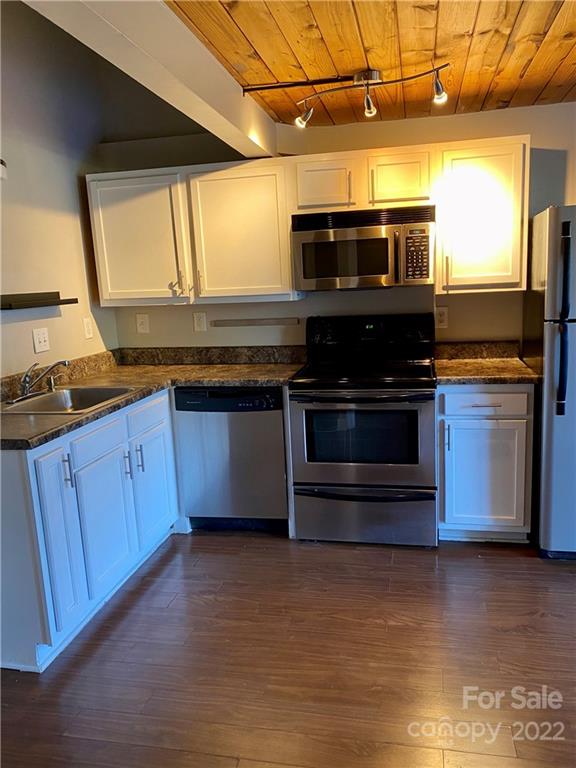 201 South Hoskins Road, Unit 326 Charlotte, NC 28208 - Photo 4 of 18 a kitchen with stainless steel appliances granite countertop a stove a sink and a microwave