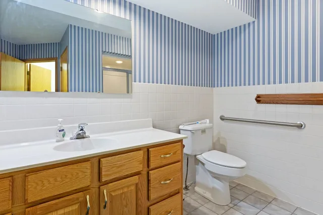 a bathroom with a sink a toilet and mirror