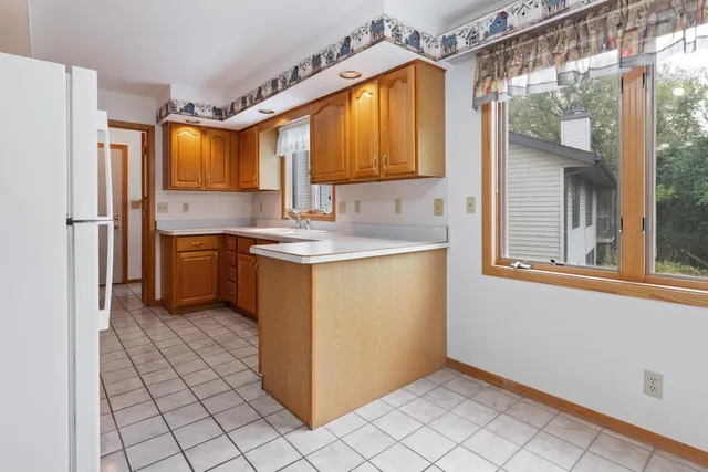a kitchen with a sink a refrigerator and cabinets