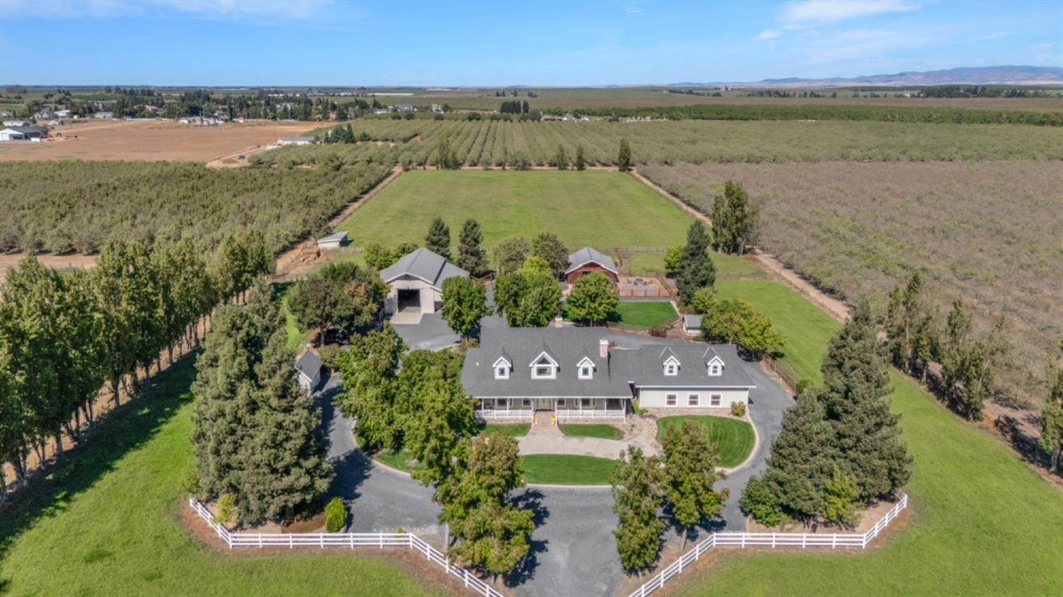 an aerial view of a residential houses with outdoor space and lake view
