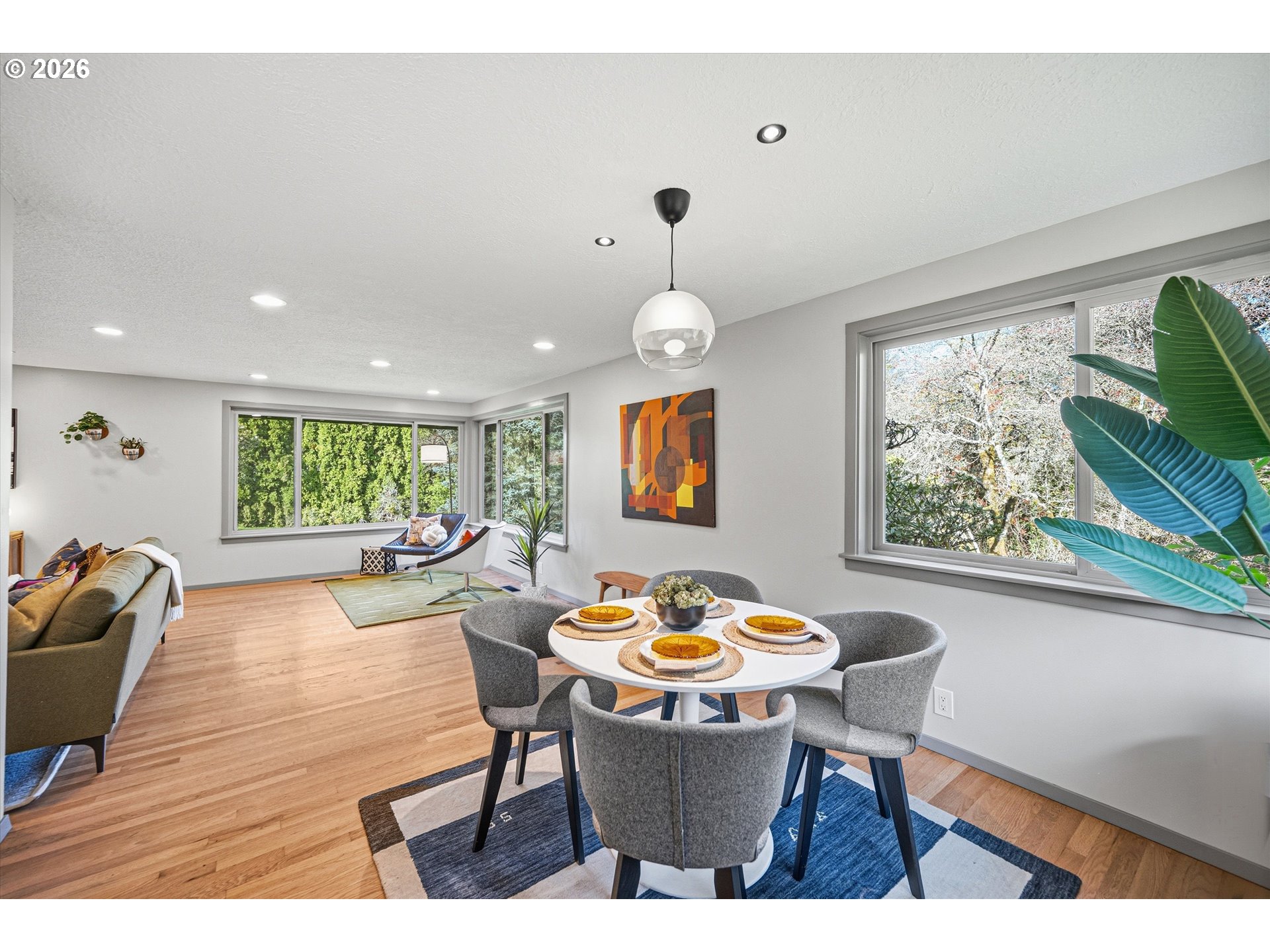 12802 Southeast Knapp Street Portland, OR 97236 - Photo 14 of 48 a dining room with wooden floor a chandelier a wooden table and chairs
