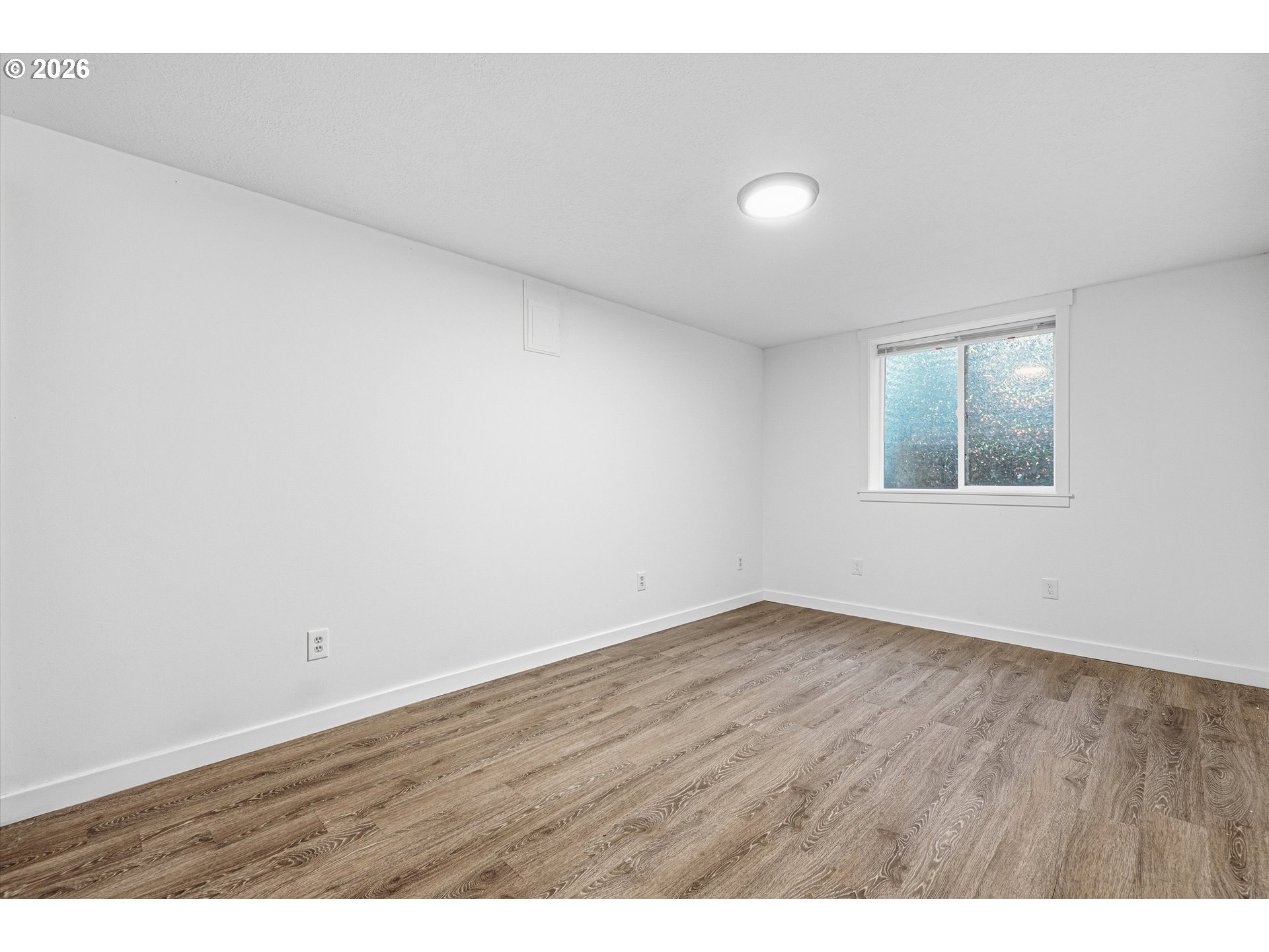 12802 Southeast Knapp Street Portland, OR 97236 - Photo 30 of 48 an empty room with wooden floor and windows