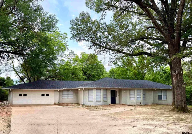a front view of a house with a tree