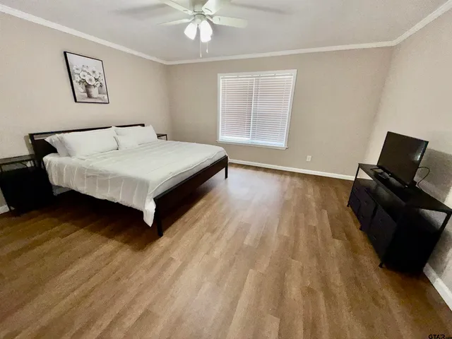 a bedroom with a bed and wooden floor