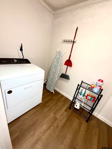 a room with gym equipment and wooden floor