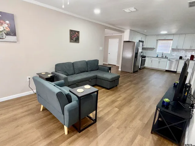 a living room with furniture and a wooden floor