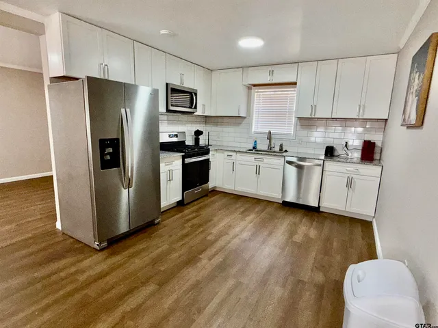 a kitchen with stainless steel appliances a refrigerator sink and microwave