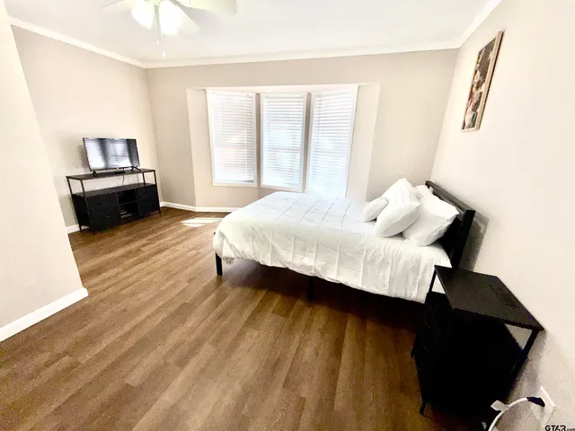 a bedroom with a bed and wooden floor