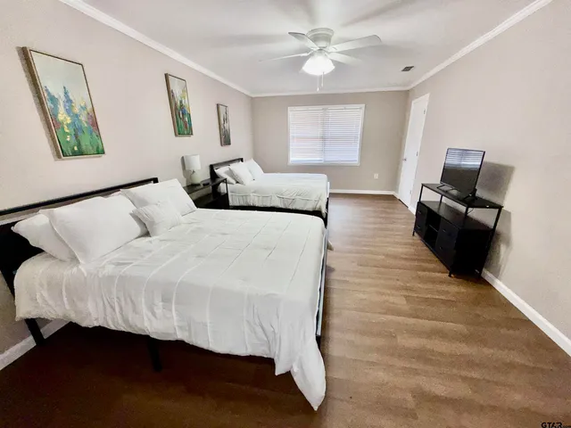 a bedroom with a bed and wooden floor