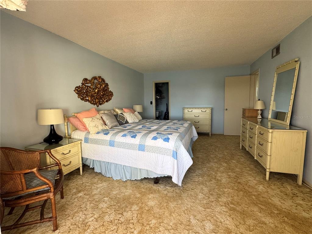 4775 Cove Circle, Unit 403 St. Petersburg, FL 33708 - Photo 16 of 42 a bed room with a bed and a chair