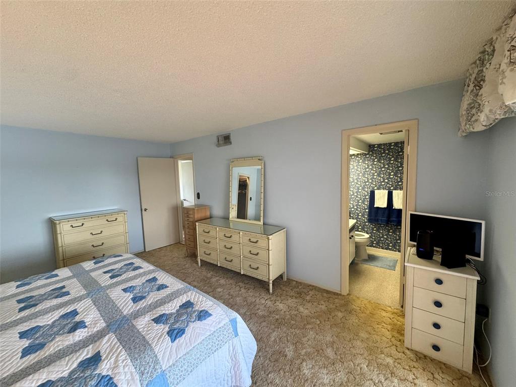 4775 Cove Circle, Unit 403 St. Petersburg, FL 33708 - Photo 17 of 42 a bedroom with a bed and furniture