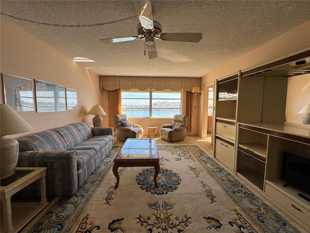 4775 Cove Circle, Unit 403 St. Petersburg, FL 33708 - Photo 7 of 42 a living room with furniture a window and a flat screen tv