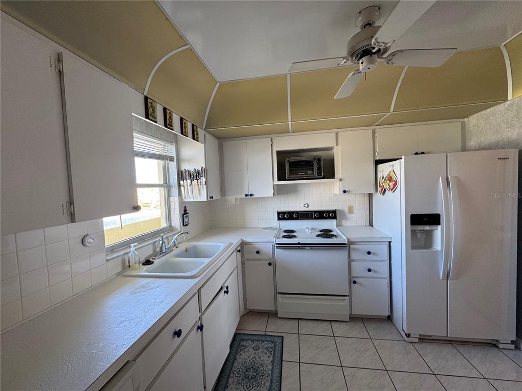 4775 Cove Circle, Unit 403 St. Petersburg, FL 33708 - Photo 8 of 42 a kitchen with a sink a counter top space stainless steel appliances and cabinets