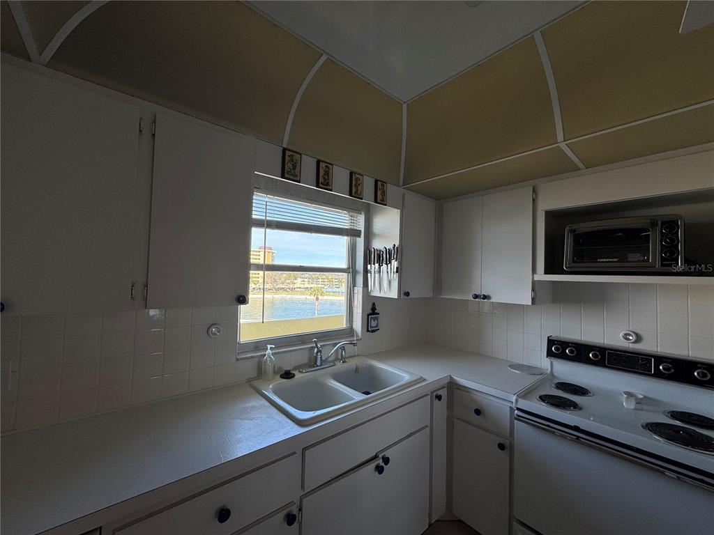 4775 Cove Circle, Unit 403 St. Petersburg, FL 33708 - Photo 9 of 42 a kitchen with a sink stove and microwave