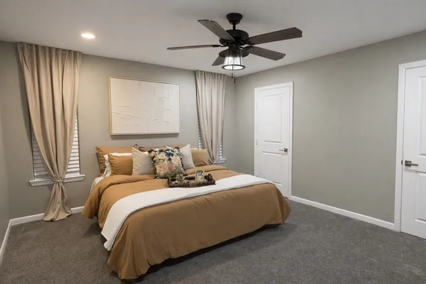 a bedroom with a large bed and a chandelier