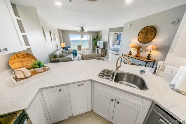 a kitchen with sink cabinets and clock on wall