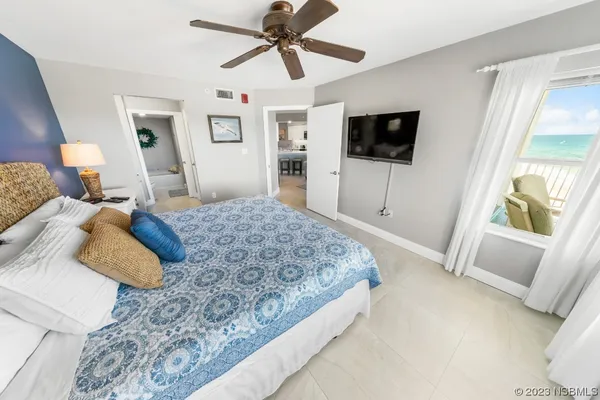 a bedroom with a large bed and a flat screen tv