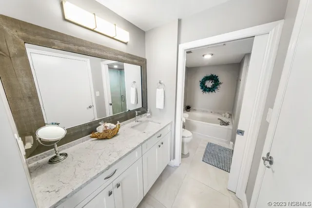 a spacious bathroom with a granite countertop sink and a mirror