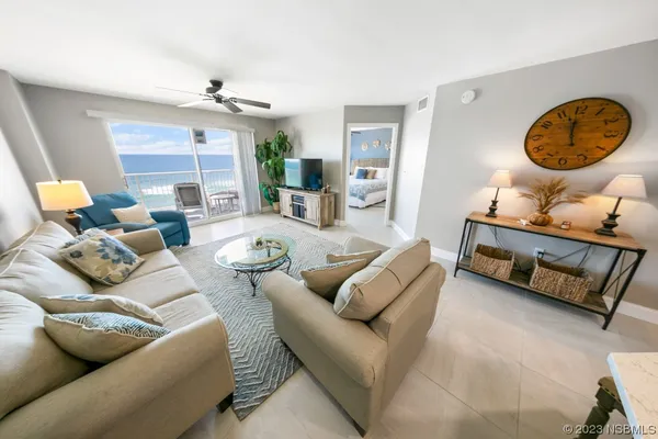 a living room with furniture a lamp and a large window