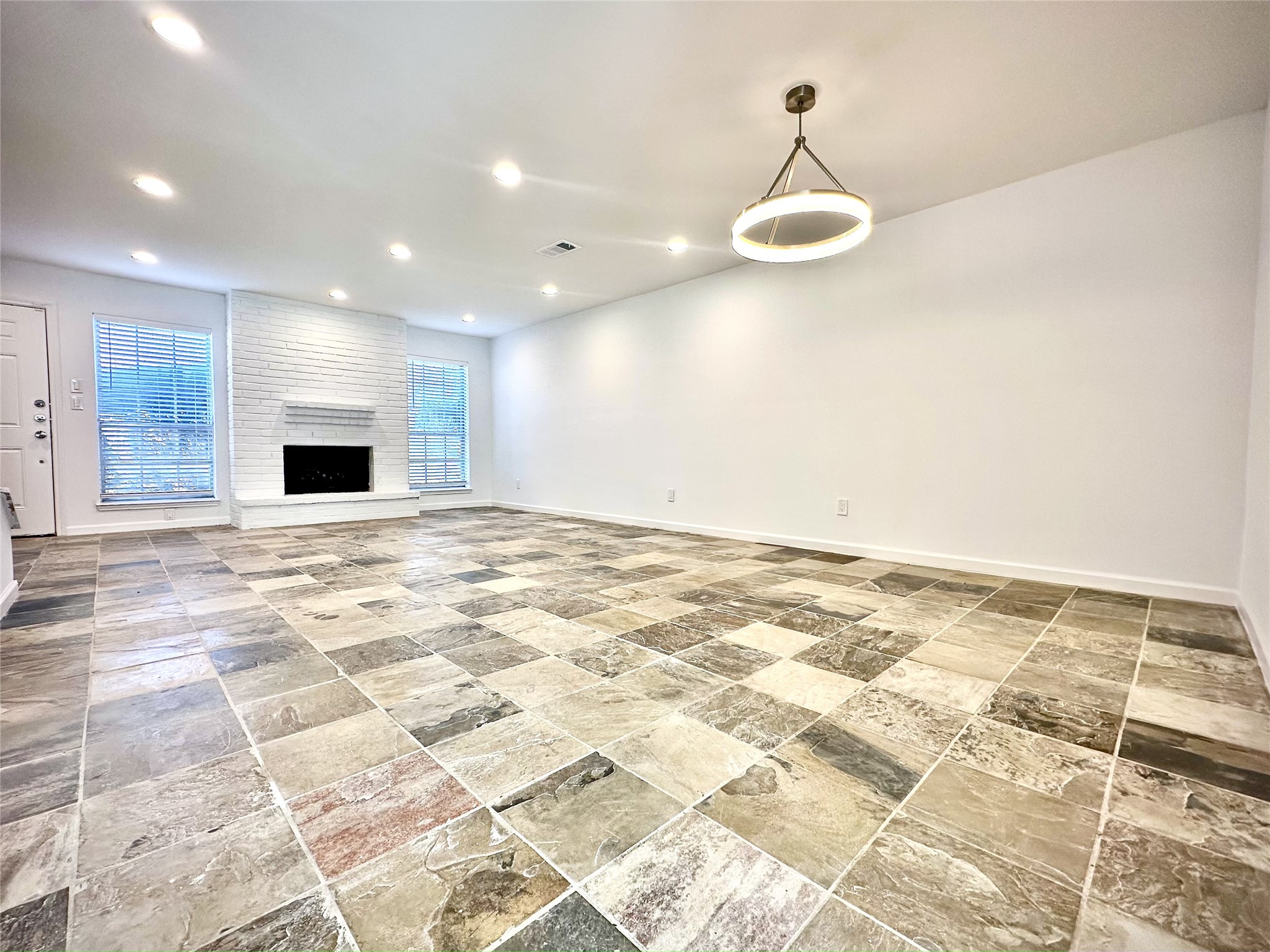 a view of a livingroom with an empty space and kitchen space