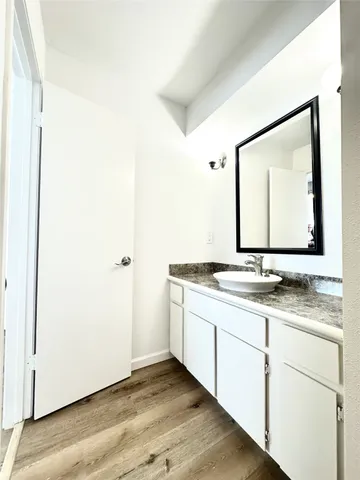 a bathroom with a granite countertop sink and a mirror