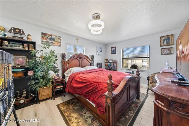 a bedroom with bed and a chandelier