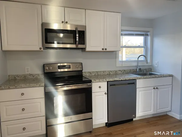 a kitchen with granite countertop a stove and a sink